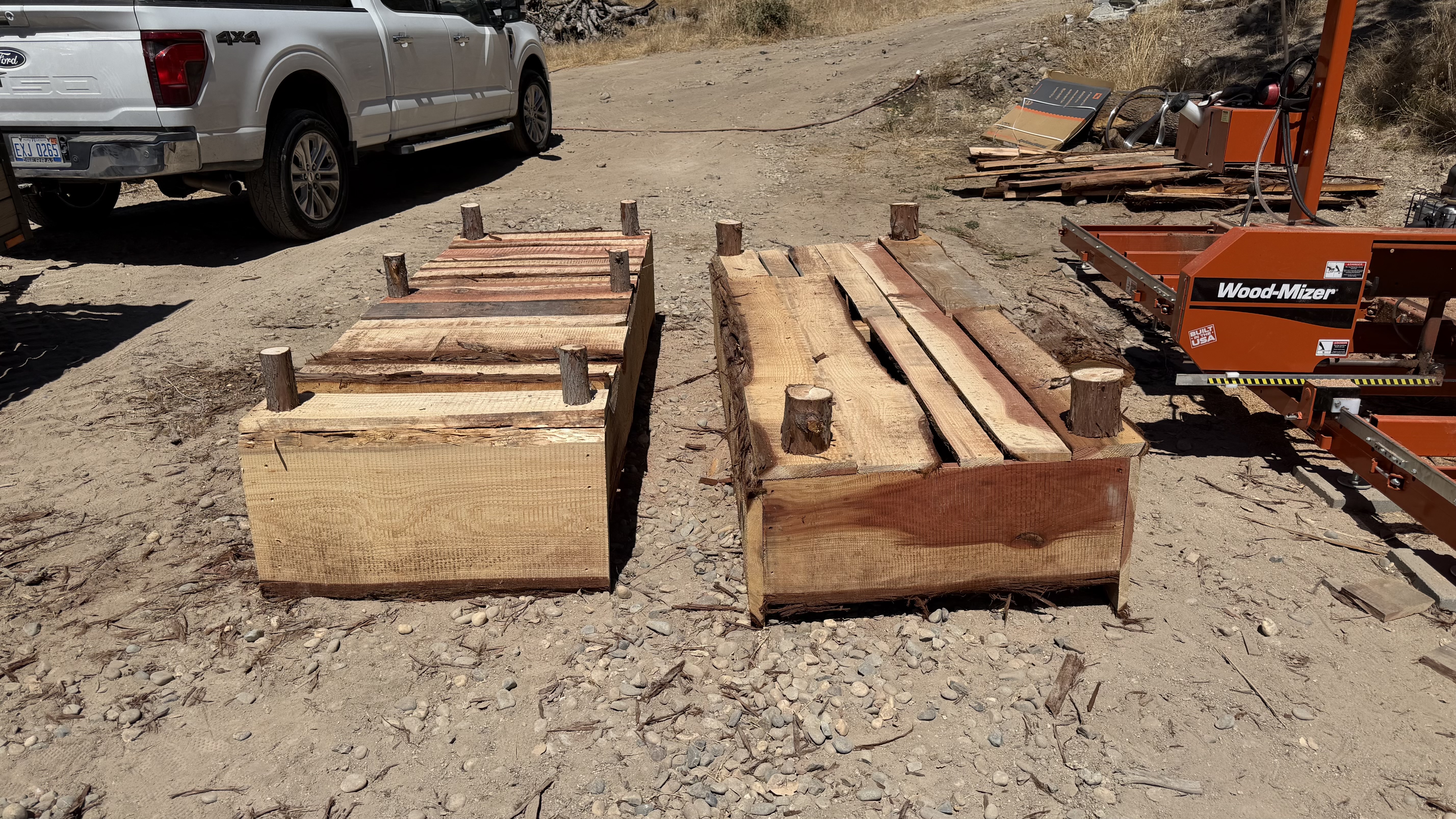 Two rough-sawn redwood planter boxes beside the mill