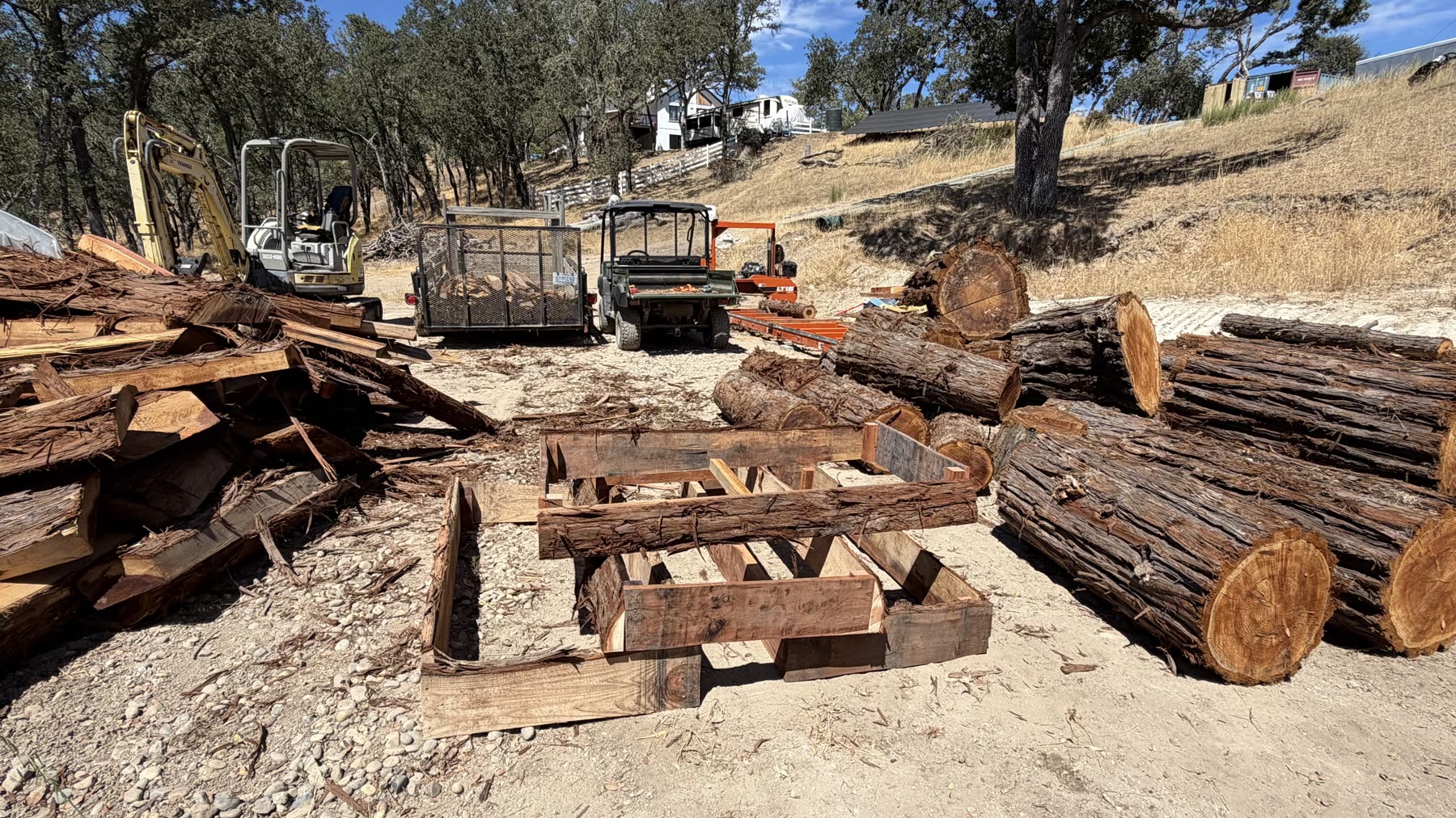 Redwood logs and freshly cut boards at the outdoor mill yard